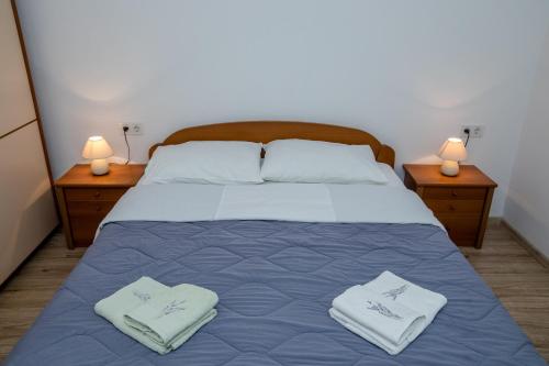 a bedroom with a bed with towels on it at Apartmani Zdenka in Rab