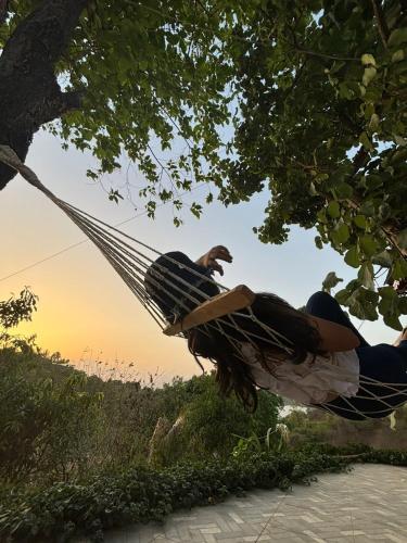 a woman laying in a hammock under a tree at ILA Villa in Vajapūr