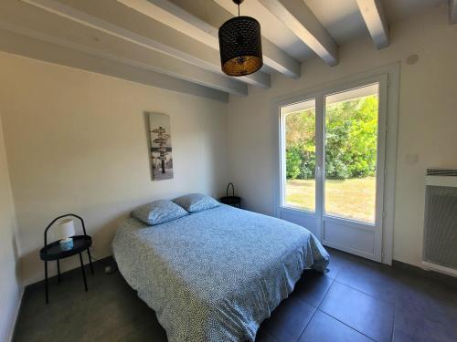 une chambre avec un lit et une fenêtre dans l'établissement DUNES - Villa Patio Avec Jardin - proche Plage de la Gravière, à Soorts-Hossegor