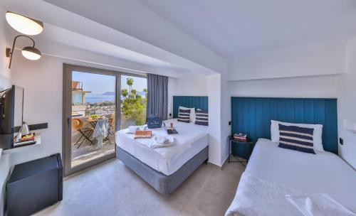 カシュにあるAphrodite Hotel Kaşのベッド2台とバルコニーが備わるホテルルームです。
