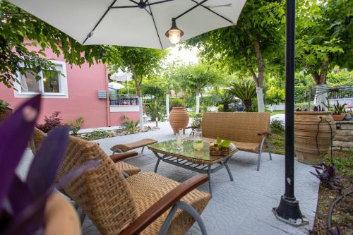a patio with a table and chairs and an umbrella at Aurora Premium Hospitality in Parga