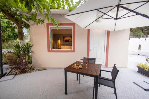 a table and chairs with an umbrella on a patio at Aurora Premium Hospitality in Parga