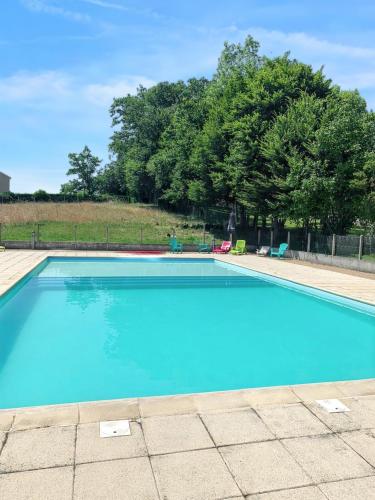 una gran piscina azul con árboles en el fondo en Maison d'une chambre avec piscine partagee jardin amenage et wifi a Leyme en Anglars