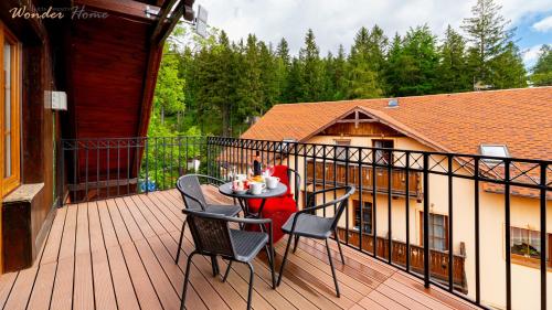 a balcony with a table and chairs on a deck at Wonder Home - Apartamenty Karkonosz blisko wyciągów narciarskich, szlaków i restauracji in Karpacz