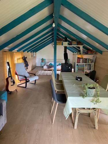 a room with a table and chairs and a guitar at Langaland Glamping in Susenii Bîrgăului