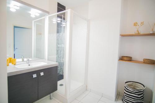 une salle de bain blanche avec lavabo et douche dans l'établissement -YSA- VUE MER - parc de la thalasso avec piscine, à Concarneau