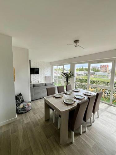 une table à manger et des chaises dans un salon dans l'établissement Le Tropical Home, à Saint-Dizier