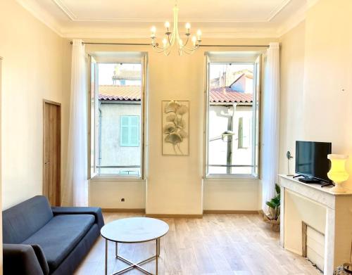 - un salon avec un canapé bleu et 2 fenêtres dans l'établissement T3 de charme 2 chambre 2 salle de bain, à Marseille