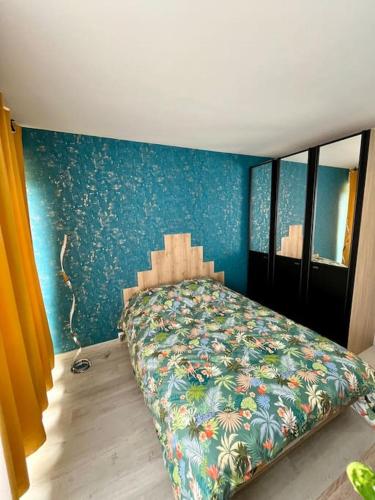 a bedroom with a bed with a blue wall at Le Tropical Home in Saint-Dizier