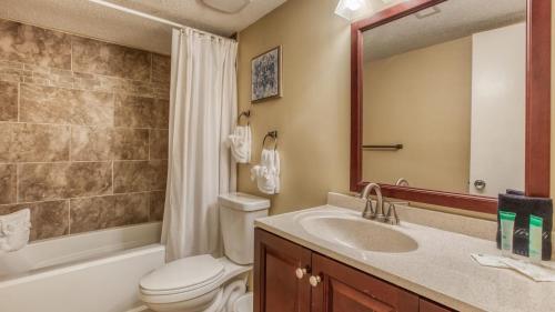 a bathroom with a toilet and a sink and a mirror at Cozy renovated ground floor unit - Golf Villa - on the Golf Course in Destin