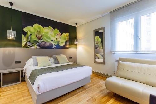 a bedroom with a large bed and a couch at Hostal Rodas Pamplona in Pamplona