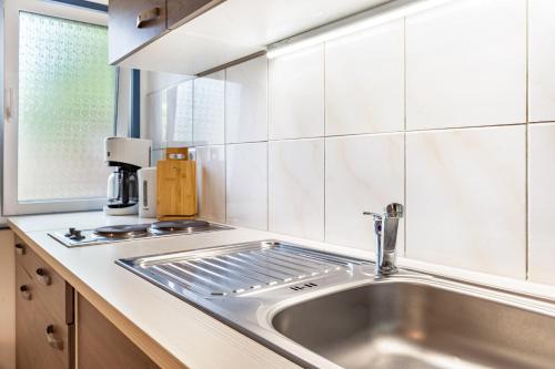 a kitchen with a stainless steel sink and a window at Bungalow Uschi - Bgl 29 in Dranske