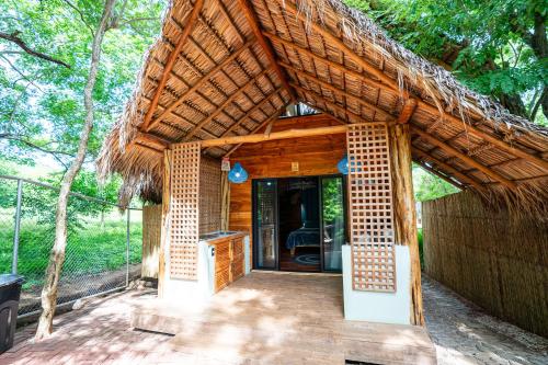 a small hut with a thatched roof at LA QUEBRADA ECO LODGE Hotel Boutique in Potrero