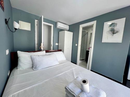 a bedroom with a large white bed with blue walls at SL Marbella in Marbella