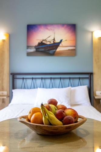a bowl of fruit on a table on a bed at Aurora Premium Hospitality in Parga