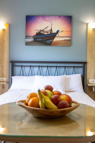 a bowl of fruit on a table in front of a bed at Aurora Premium Hospitality in Parga