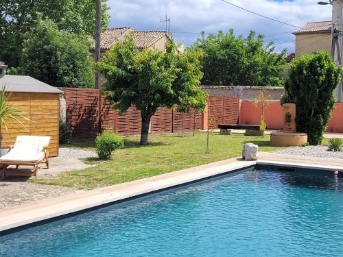 a swimming pool in a yard with a fence at Gîte l'atelier de Phil et Delfe in Sainte-Cécile-les-Vignes