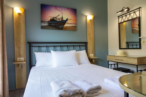 a bedroom with a white bed with towels on it at Aurora Premium Hospitality in Parga