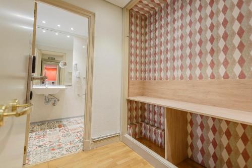 a bathroom with a shower with a sink and a mirror at Hostal Rodas Pamplona in Pamplona