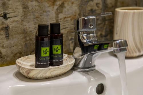 two bottles ofodorizers sitting on top of a sink at Aurora Premium Hospitality in Parga