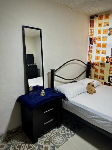 a bedroom with a mirror and a teddy bear sitting on a bed at Alborada 2 Cerca del Aeropuerto in Mexico City