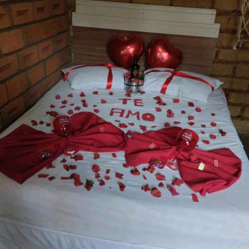 a bed with red hearts and flowers on it at Sítio Estrela da Manhã Hospedagem e Lazer in Palmeiras
