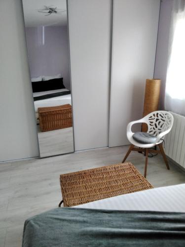 a bedroom with a bed and a chair and a mirror at La pause ô logis gourmande in Navarrenx