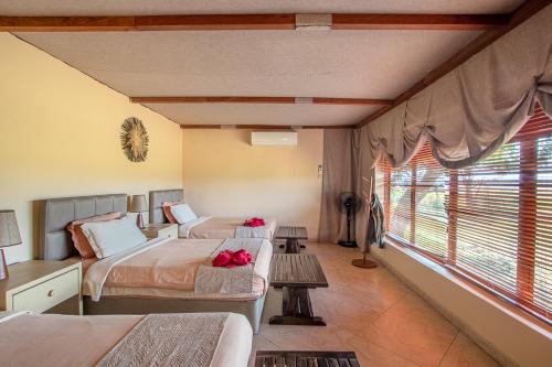 a bedroom with two beds and a window at Mopani Safari Lodge in Mfuwe