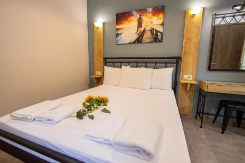 a bedroom with a bed with towels and a piano at Aurora Premium Hospitality in Parga