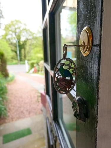 a door knob with a bird on a window at Tigh N Eilean Self Catering Aberfeldy in Aberfeldy