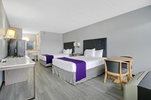 a hotel room with two beds and a television at Home 1 Suites Extended Stay - Kissimmee in Kissimmee