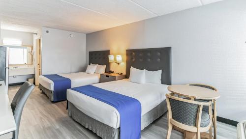 a hotel room with two beds and a table at Home 1 Suites Extended Stay - Kissimmee in Kissimmee