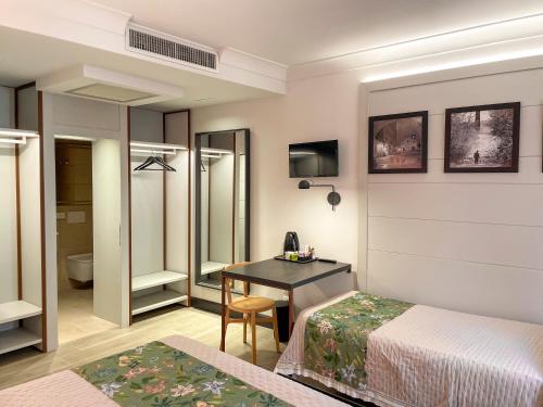 a bedroom with a bed and a desk with a table at Duccio Nacci Rooms- Guesthouse in San Gimignano