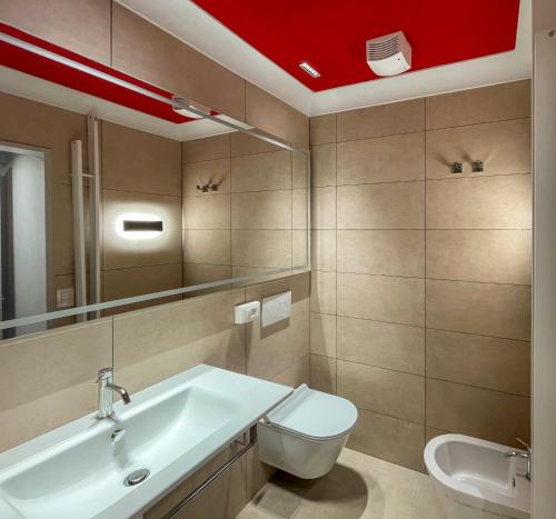 a bathroom with a white sink and a toilet at Duccio Nacci Rooms- Guesthouse in San Gimignano