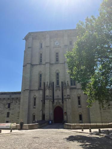 a large stone building with a clock on it at Appartement chateau de Vincennes JEUX OLYMPIQUES in Vincennes