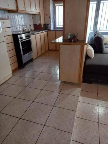 a kitchen with a large tiled floor with a couch at Dolce Vita - In the heart of Lefkada - Lefkada BnB in Lefkada Town
