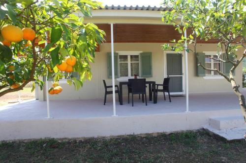 a patio with a table and chairs in front of a house at Olga Home Agios Ioannis Lefkada - Lefkada BnB in Lefkada Town