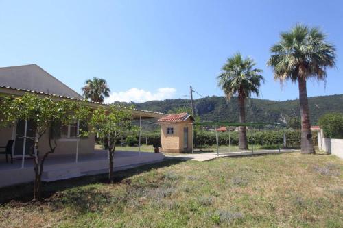 a house with palm trees and a yard at Olga Home Agios Ioannis Lefkada - Lefkada BnB in Lefkada Town