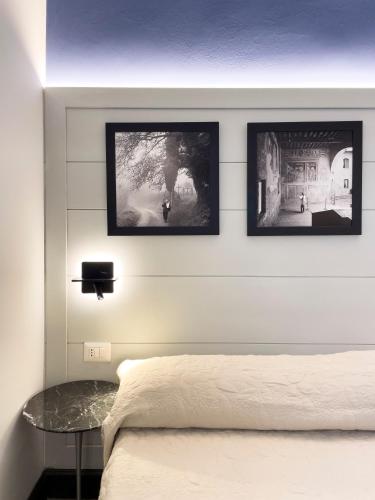 a bedroom with three pictures hanging above a bed at Duccio Nacci Rooms- Guesthouse in San Gimignano
