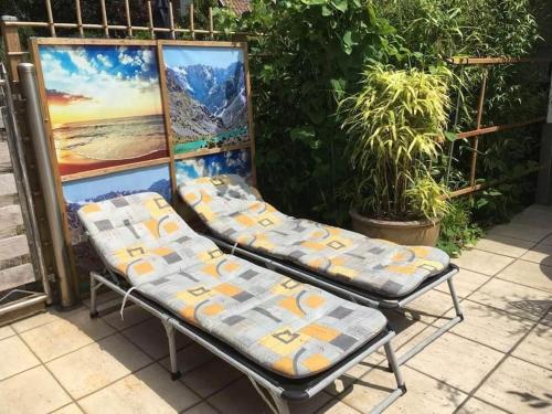 a pair of chairs sitting in front of a painting at Le petit Nid a Coxyde in Koksijde