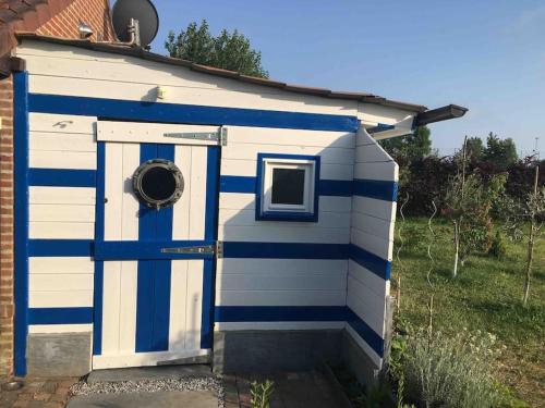 a blue and white out house with a door at Le petit Nid a Coxyde in Koksijde