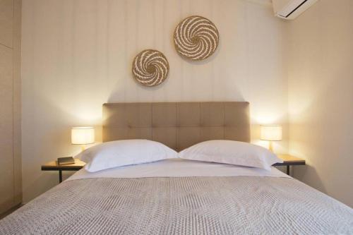 een slaapkamer met een bed met 2 lampen en 2 kussens bij Sunny Apartment Lefkada - Lefkada BnB in Lefkada