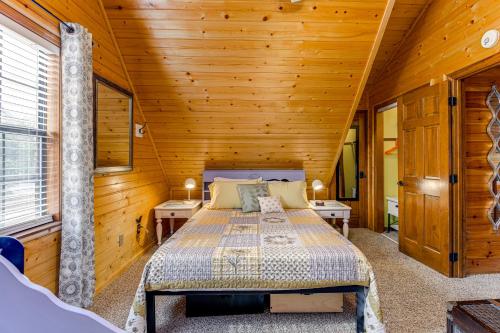 a bedroom with a bed in a wooden cabin at Easy-Access Pigeon Forge Cabin with Hot Tub! in Pigeon Forge