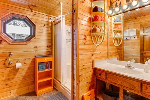 a bathroom with a sink and a mirror at Easy-Access Pigeon Forge Cabin with Hot Tub! in Pigeon Forge