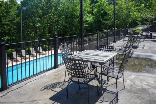 a table and chairs sitting next to a pool at Easy-Access Pigeon Forge Cabin with Hot Tub! in Pigeon Forge