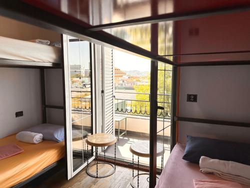 a room with two bunk beds and a balcony at Divina Hostel in Tirana