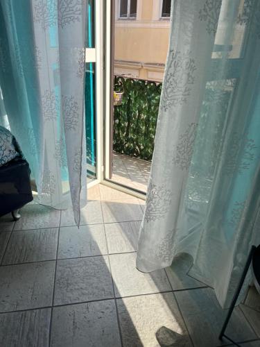 une porte ouverte avec des rideaux et une vue sur une fenêtre dans l'établissement B&B Il Corallo, à Terracine