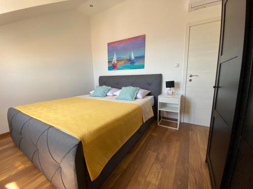 a bedroom with a bed with a yellow bedspread at Penthouse Vanja in Bol