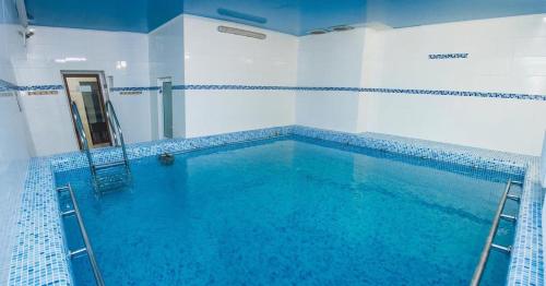 a large swimming pool with blue water in a room at LidoLux in Bălţi