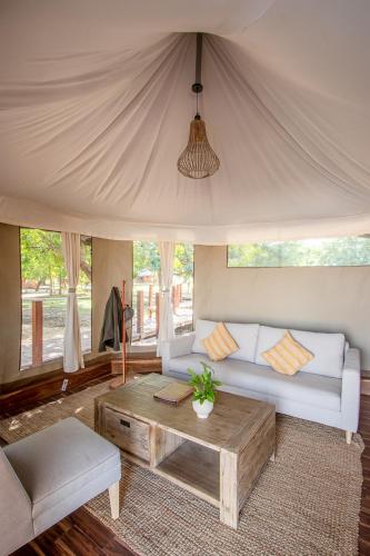 a living room with a couch and a coffee table at Mopani Safari Lodge in Mfuwe
